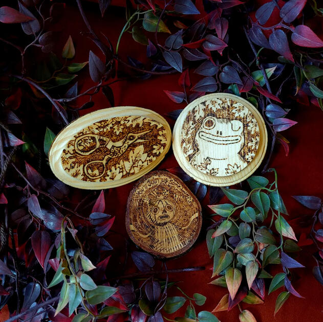 A trio of woodburned plaques inspired by the cartoon Over The Garden Wall